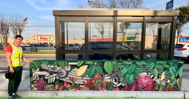 Artisit Santiago Perez stands in front of a bus shelter mural he created in Gulfton.