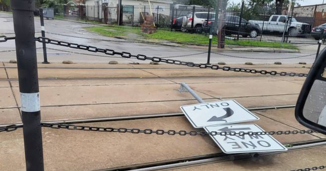 A broken rail sign lies on the ground after Beryl.