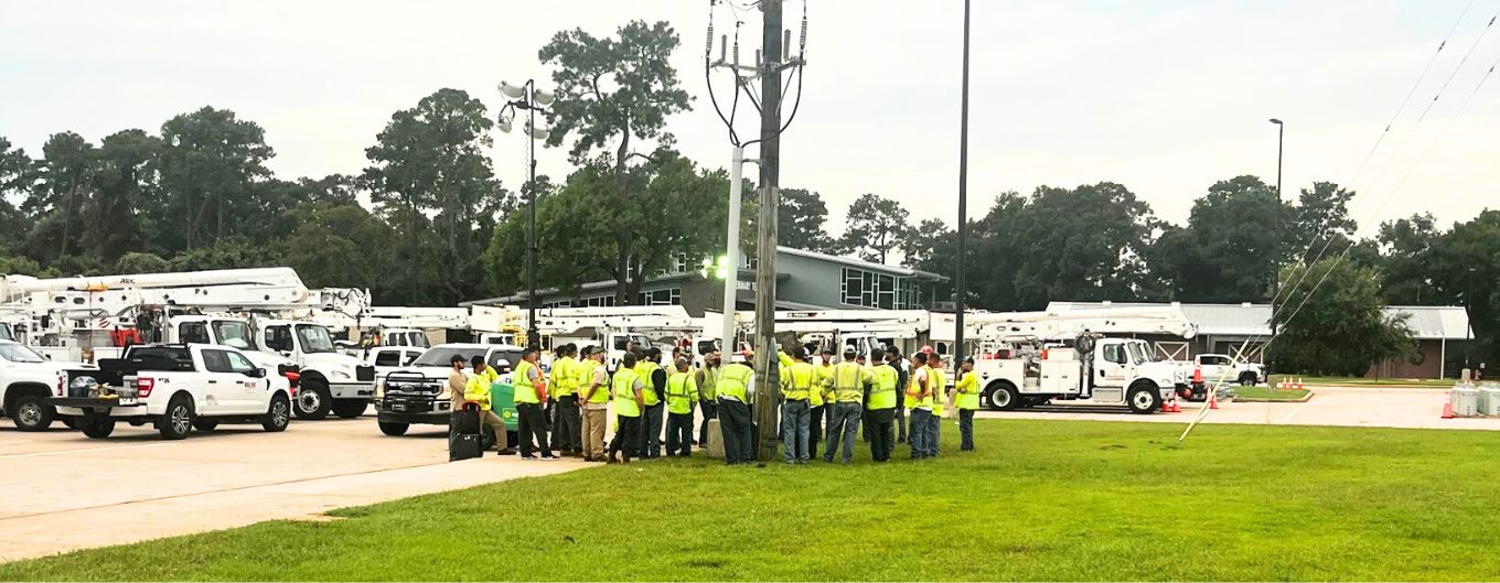 Centerpoint workers gather in a community parking lot to review restoration plans.