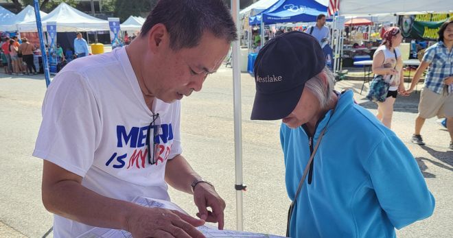 A METRO public engagement employee shows a community members various routes on a METRO map.