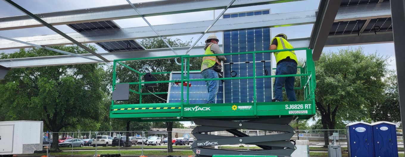 Workers install a solar panel.