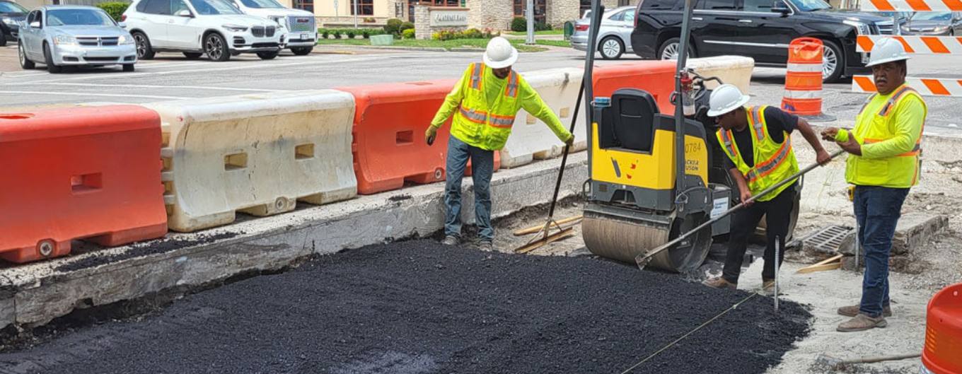 Workers lay new asphalt along Westheimer Road