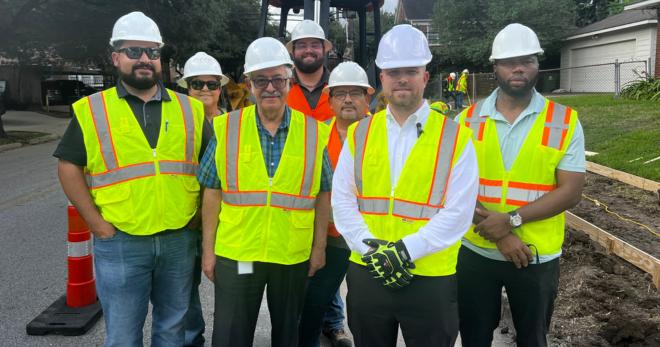 82 BOOST Workers in yellow safety vests pose for a group photo.