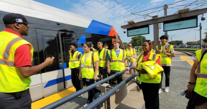 Students board a METROlight rail train with a METRO instructor.