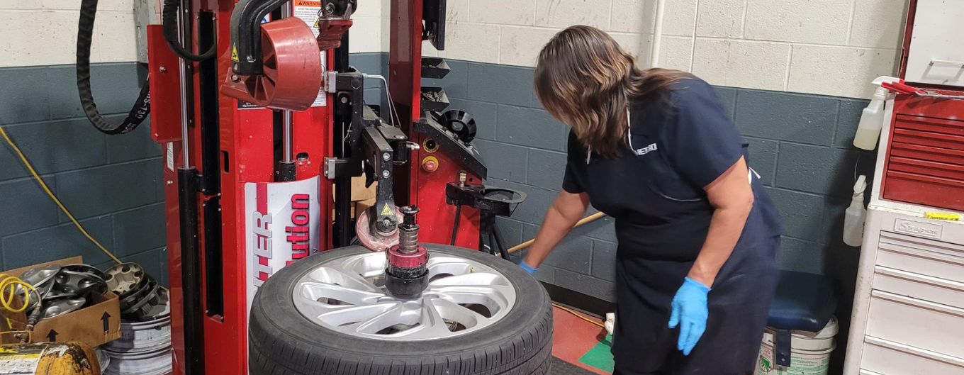 A woman works on a tire in METRO's tire shop.
