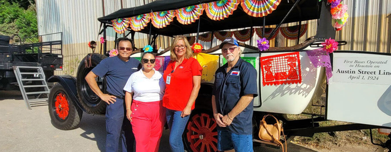 Group photo in front of the small tour bus of staff on Dia de los Muertos celebration at Magnolia Park.