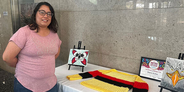 METRO employee, Maira Aviles standing next to her art work.