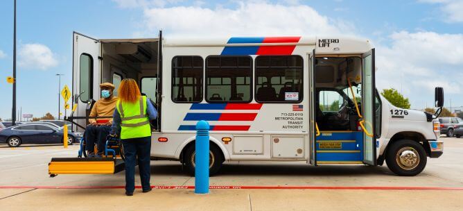 METRO paratransit representative assisting customer using METROLift vehicle's electric lift.