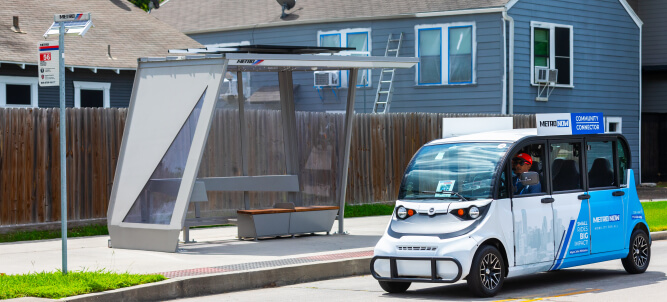 Community Connector vehicle traveling near a METRO bus stop.