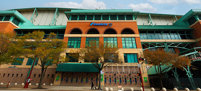 Daikin Park during the day with one person walking in front.