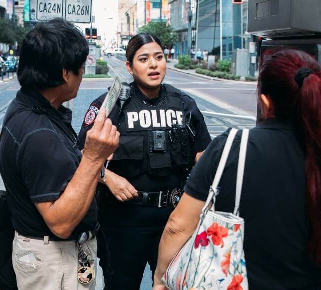 METRO police officer speaking with customers on a rail platform in downtown Houston