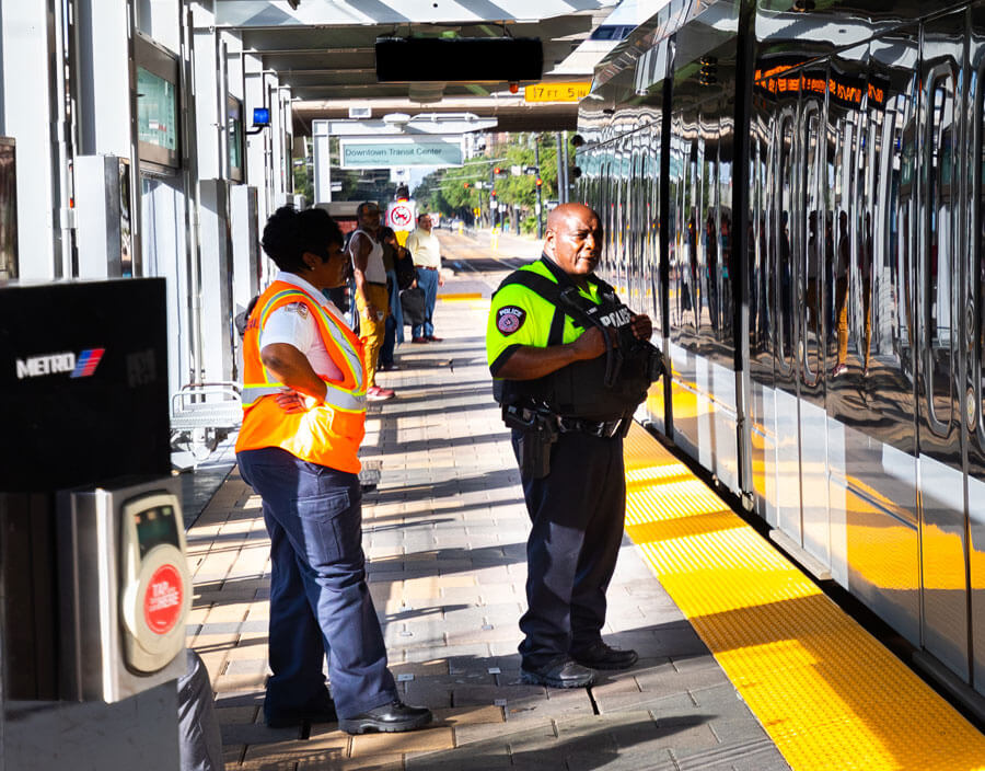 METRO Police Officer with METRO Safety employee waiting at METRORail platform to board train.