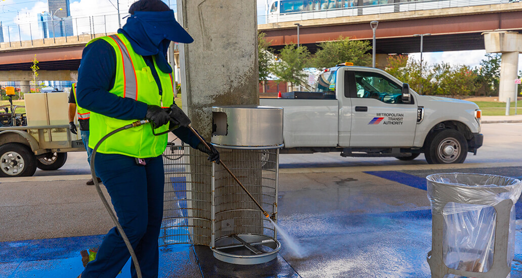 Trash removal and powerwashing of trash bins at a transit center.