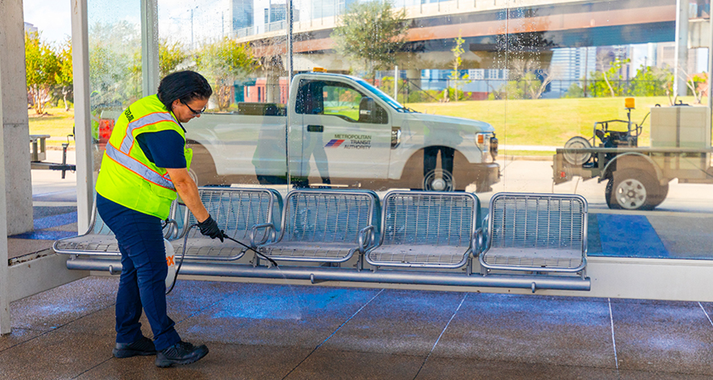 METRO employee washing the seating areas and surrounding waiting areas.