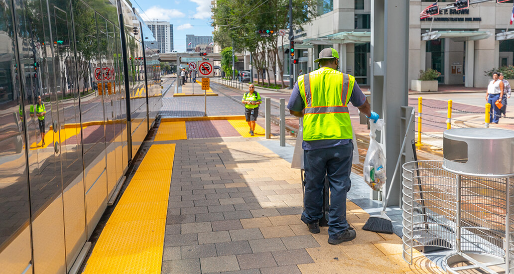 Trash being removed from trash bins at a METRORail platform.