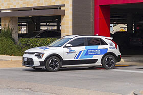 23236-Community-Connector A Community Connector crossover SUV driving away from an H-E-B in the Heights zone.