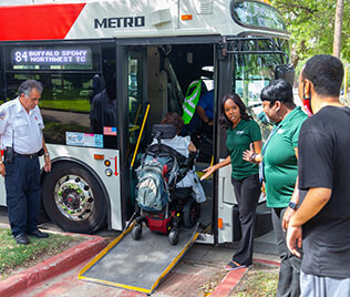 15978-travel-training-session-316x268 Travel trainers showing how to use a bus ramp.