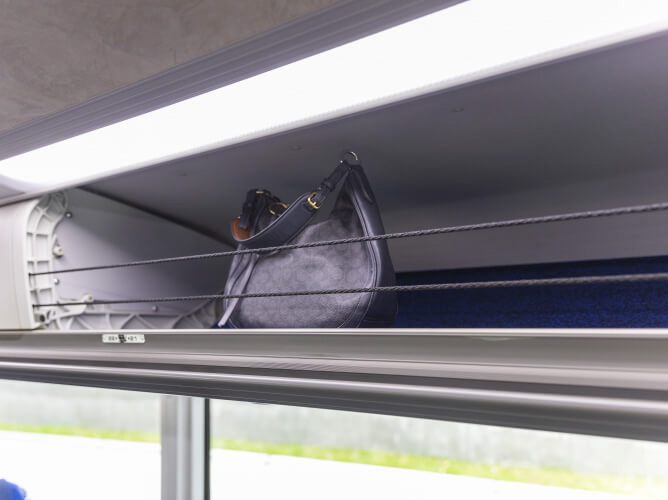 Customers belongings stored in the overhead storage bin on a Park & Ride bus.