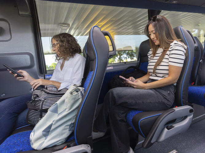 METRO customers sitting in cushioned, coach-style seats onboard a Park & Ride bus.