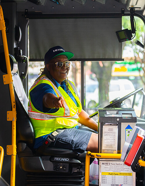 METRO bus operator smiling in the drivers seat.