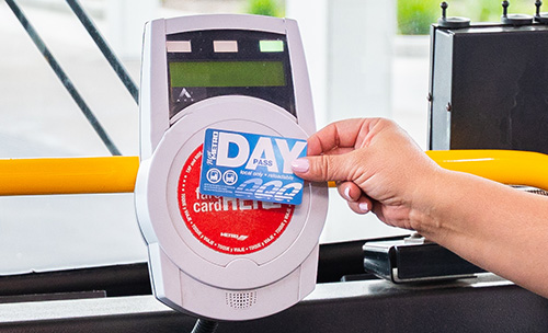 Customer tapping METRO Day Pass on fare validator when boarding.