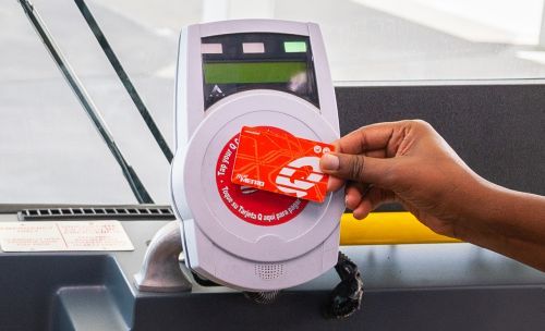 Customer tapping METRO Q® Fare Card on fare validator when boarding local bus.