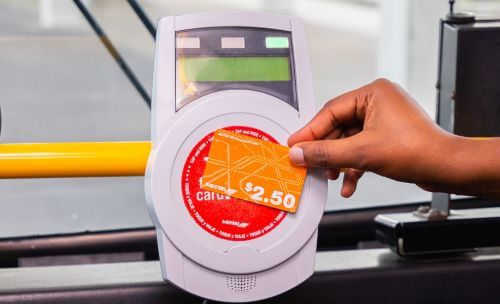 Customer tapping METRO Money card on fare validator when boarding.