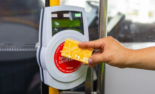 Customer tapping METRO Money card on fare validator when boarding.