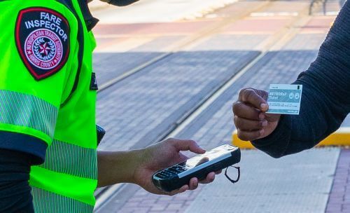 Customer showing METRORail vending machine ticket to fare inspector